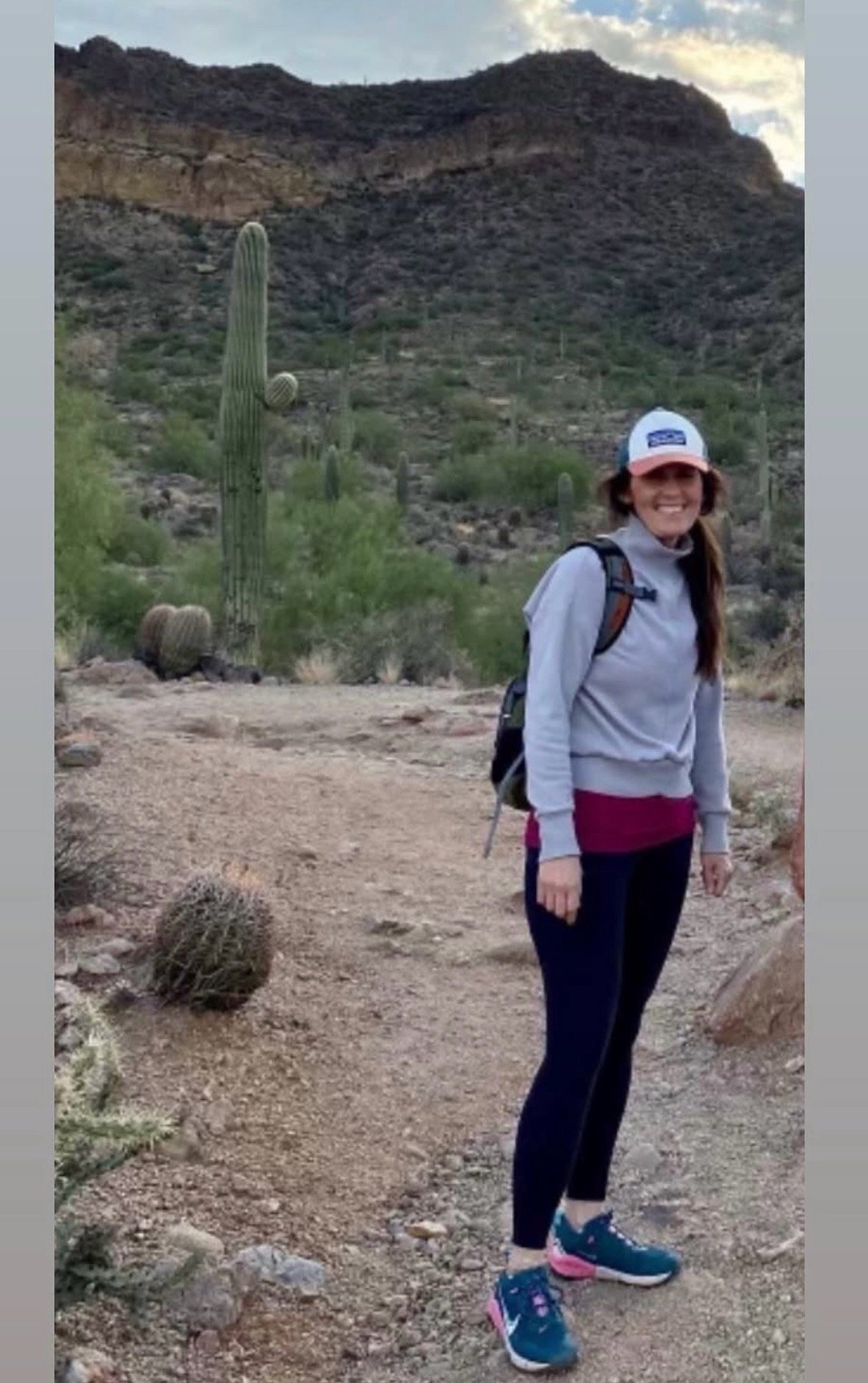 Lori Pappin hiking a scenic desert trail alongside giant saguaro cacti
